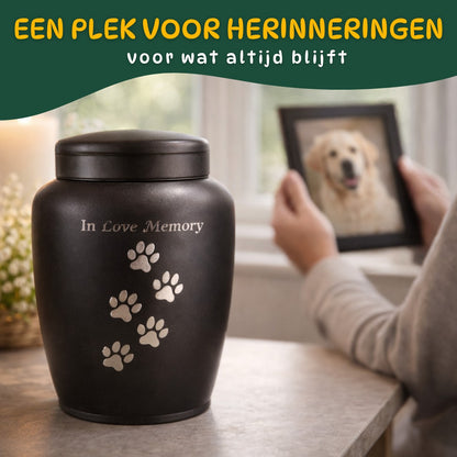 hondenurn met pootafdrukken op tafel terwijl iemand een foto van zijn hond vasthoudt rustige herinneringssfeer